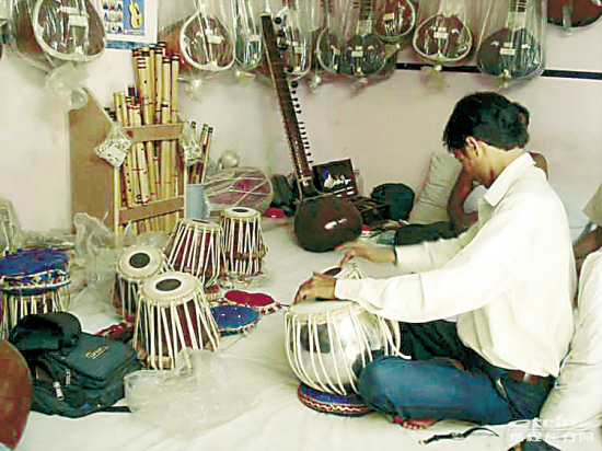 小巷里的乐器店,伙计正在调试印度鼓